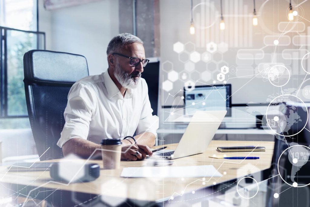 Concept d'écran numérique avec icône virtuelle, diagramme, graphique et interfaces. Homme d'affaires portant des lunettes classiques et travaillant sur un bureau en bois.